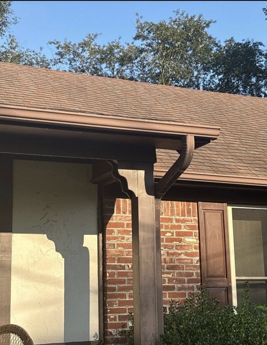 Close-up detail of shingles and gutter on a residential roof repair.