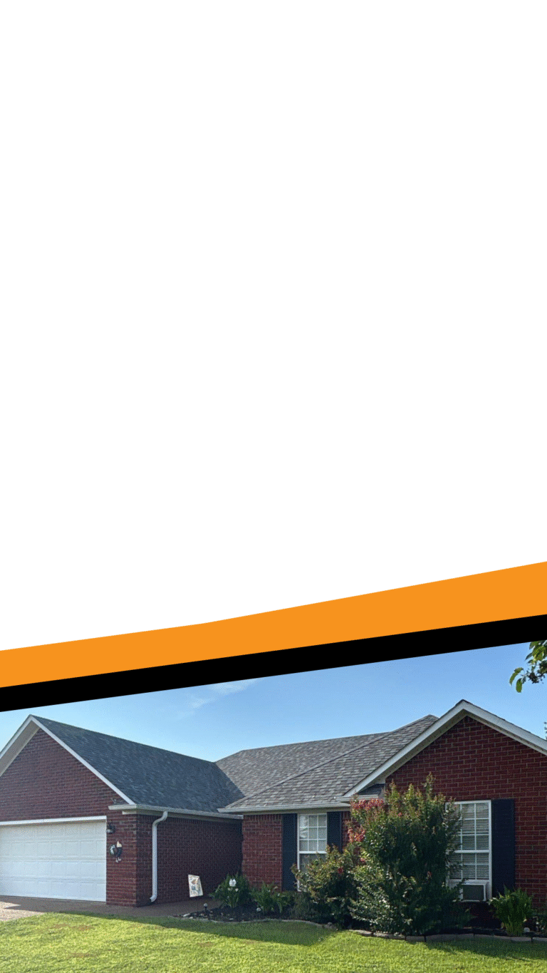 Roof replacement on red brick home with black shutters and white garage door in Jackson, TN.